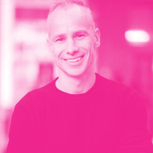 Aaron Brindle's headshot with a hot pink filter.